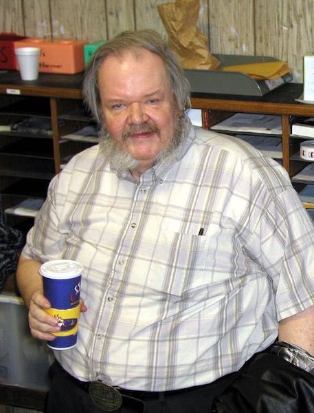 a hairy and unkempt man holding a soda cup. To be honest he looks pretty creepy.