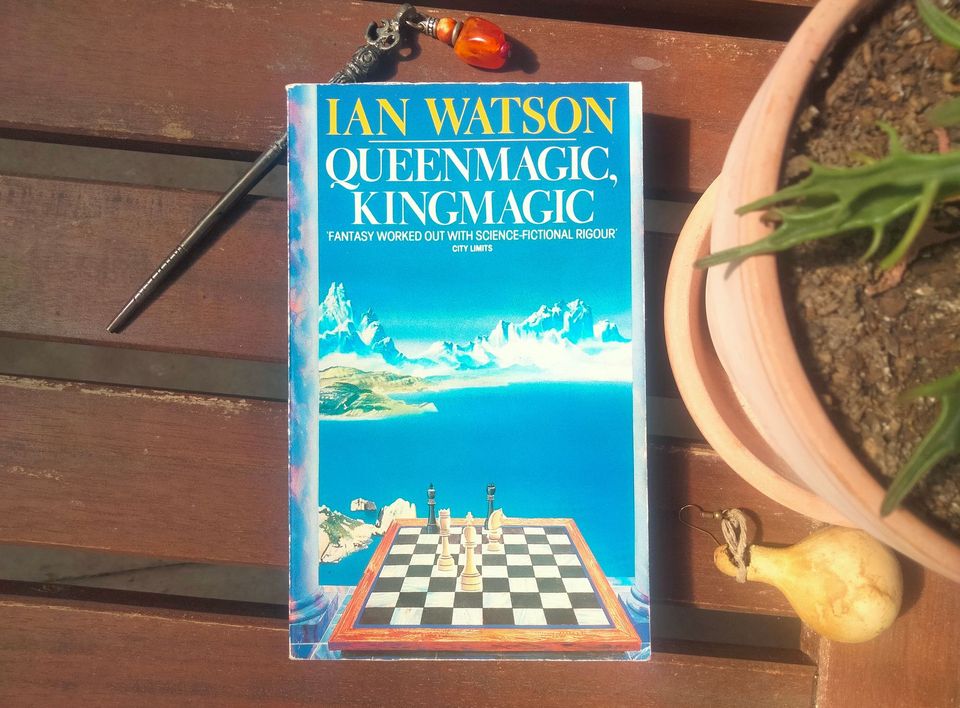 Book cover featuring a chess board in front of a fantasy-looking lake and mountains