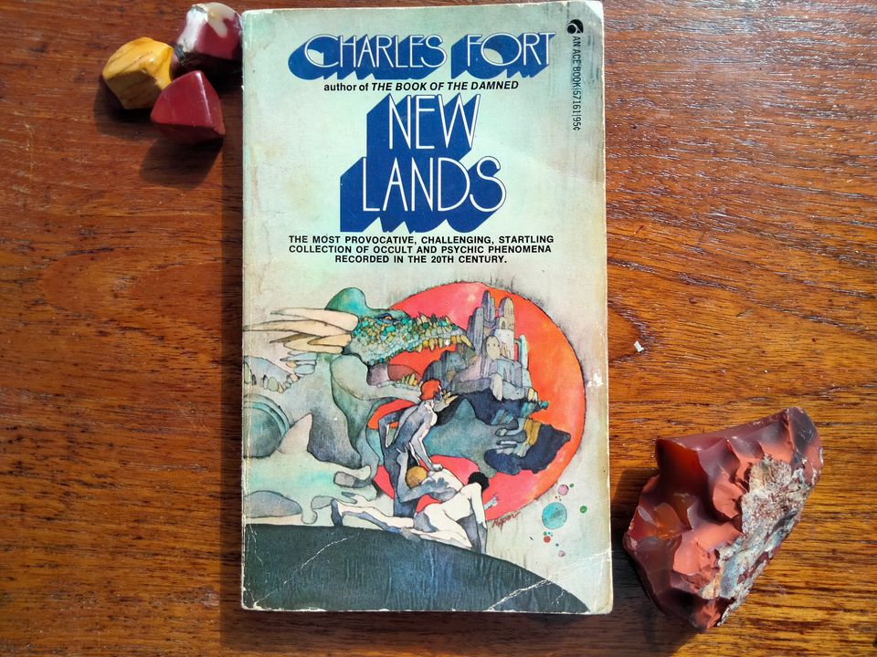 Paperback copy of "New Lands" by Charles Fort, depicting a dragon and flying castle